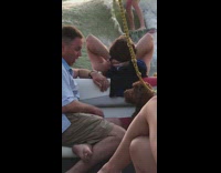 Man talking and blowing kisses to dog on boat