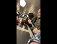 Guy pours out alcohol bottle pours into cup 