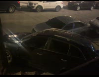 Black SUV parked slanted on curb night