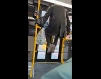 Man pushing himself up on bus handrails