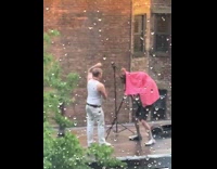 2 guys pose for self timer in white and pink outfits 