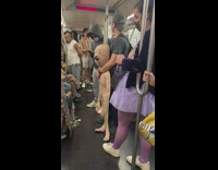 Man on subway with alien toy blue mask 