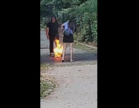 Girl kneels by fire park bridge arch