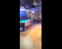 Man at bar playing pool while on horse