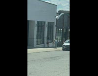 Black shirt girl sidewalk white pink building 