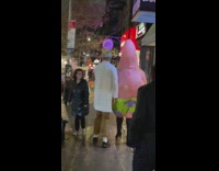 Person wearing patrick costume with boots walking on street