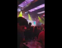 Guy in hoodie and hat reading through papers in club