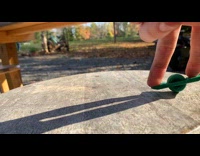 Filmer perform trick on small green onewheel