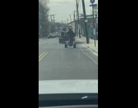 Guy in 4 wheeler does wheelies on the street