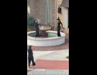 Two women witch costume dances at fountain