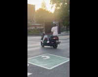 Two guys transport large TV riding motorbike