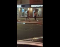 Woman carry dumbbells cross the street night