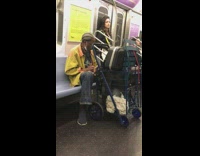 One guy dances while another sleeps on subway