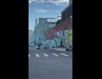 Guy poses with blue smoke bomb in front of wall 