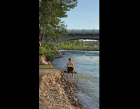 Girl sits on wood splashes lake water