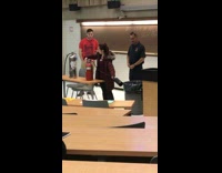 Girl in huge red jacket sprays fire extinguisher in classroom