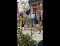 Purple bra black shorts guy dances sidewalk 