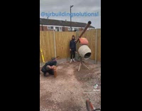 Worker singing acapella into pipe while coworker helps