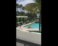 Girl poses by pool green striped umbrella 