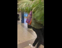 Guy speeding through train station carrying plants