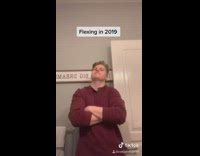 Guy flexes toilet paper rolls red shirt