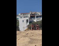 Two woman in bikini dance at the beach