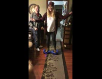 Girl rides on blue hoverboard loses balance and falls on living room floor