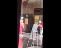 Woman pink outfit lean on cinemas column