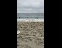 Three surfers pink surfboards fall off get knocked out by wave beach sand water