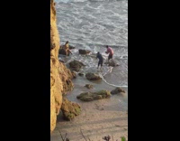 Woman green bikini sit on rock beach