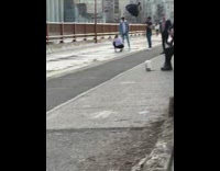 Man in a checkered top in the middle of the bridge
