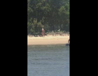 Boat pass by woman pink hat beach