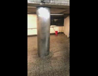 Water running down subway station behind white walls