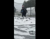 Boy bounce on trampoline with snow slow motion