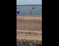Rainbow umbrella blows away wind beach girl 
