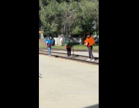 Three people train costumes video at railroad