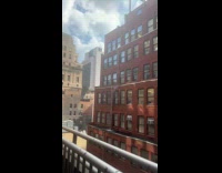 Broken pipe outside brown building bursts water