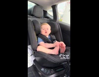 Adorable toddler babbling while on car seat 