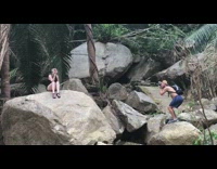 Girl sitting on rocks waterfall