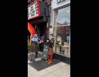 Bag pipe players and leprechaun outside store and theater
