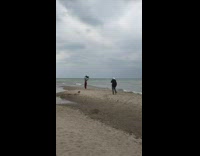 Woman red bottoms sweater wave windy beach