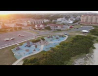 Drone flies over beach parking lot sunset