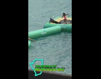 Girl runs on inflatable tube falls water