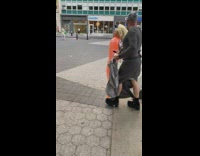 Man walks up stairs with naked Trump figurine 