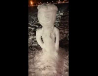 Snowman snow sculpture at park with hair 