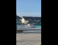 couple in white walks toward tripod slowly