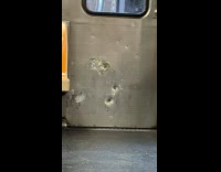 Train doors with caved in bullet holes