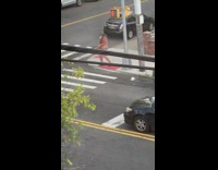 Man shirtless holds a white bike tire on the sidewalk
