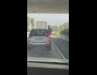 Man black shirt film outside car window highway