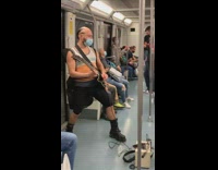 Guy on subway plays black electric guitar 